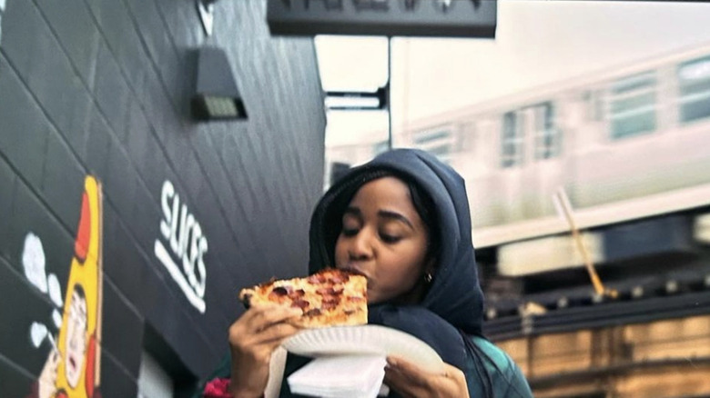 Sydney eating slice of pizza