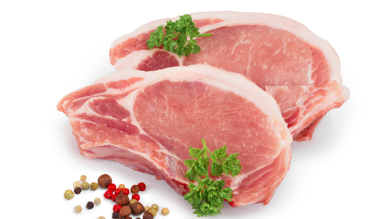 two raw pork chops with parsley