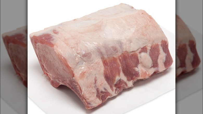 raw pork rib roast on white cutting board