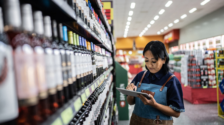 Liquor store clerk with bottles