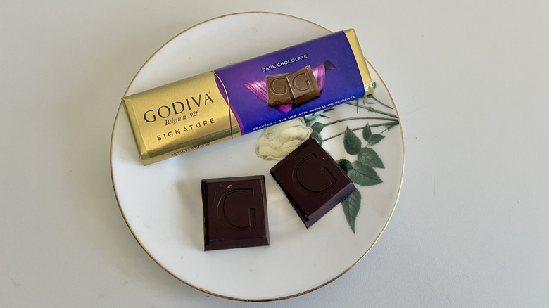 A Godiva dark chocolate small bar is shown on a plate.