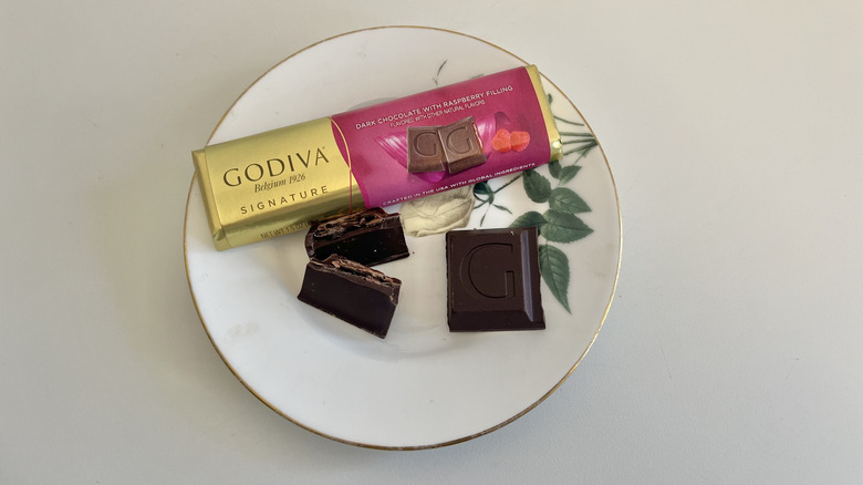 A Godiva raspberry chocolate bar is shown on a plate.