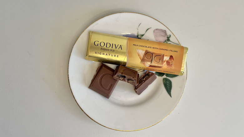 A Godiva caramel-filled milk chocolate bar is shown on a plate.