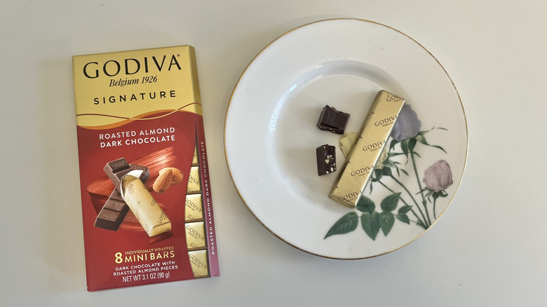 A Godiva dark chocolate with almond bar is shown on a plate.