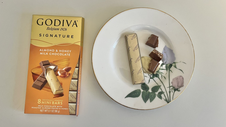 A Godiva almond and honey milk chocolate bar is shown on a plate.