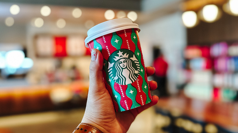 Person holding Starbucks holiday cup