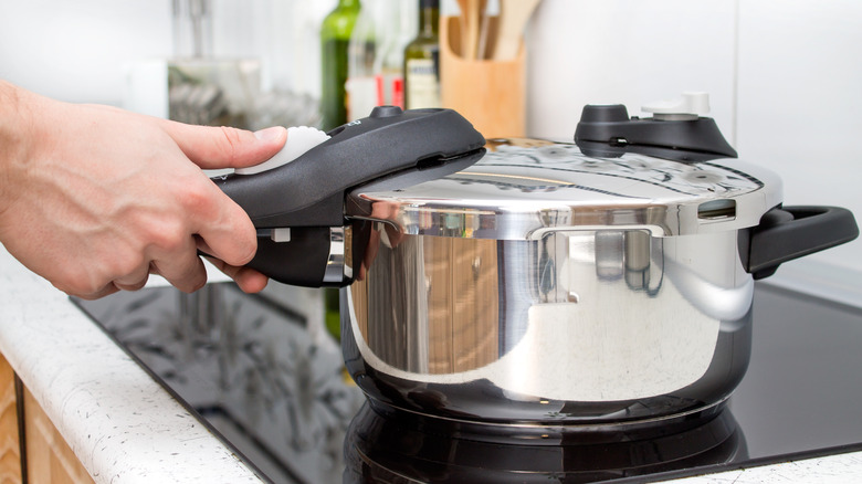 Person securing pressure cooker lid