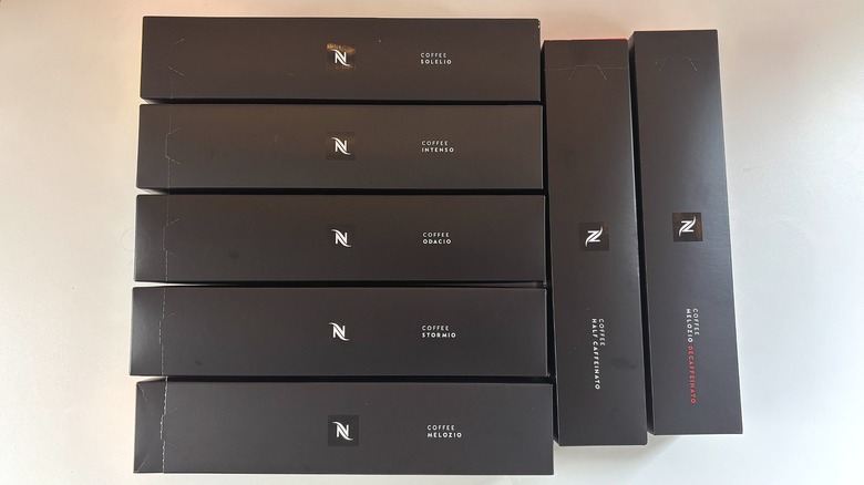 Seven boxes of Nespresso pods on white table