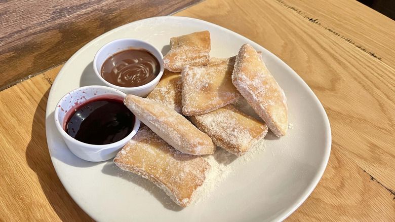 Olive Garden's Italian donuts on a plate with dipping sauces