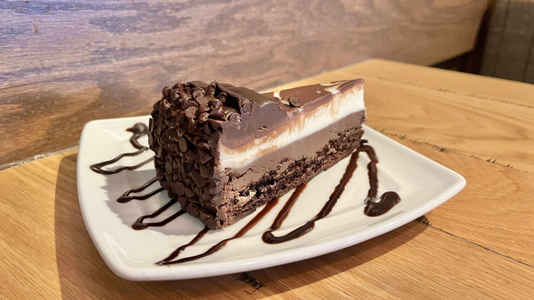 A slice of Olive Garden's Black Tie Mousse cake on a white plate