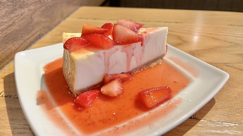 A slice of Olive Garden's strawberry cheesecake dessert on a white plate