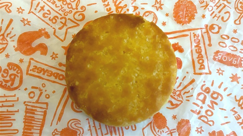 Overhead shot of Popeyes biscuit on Popeyes wrapper