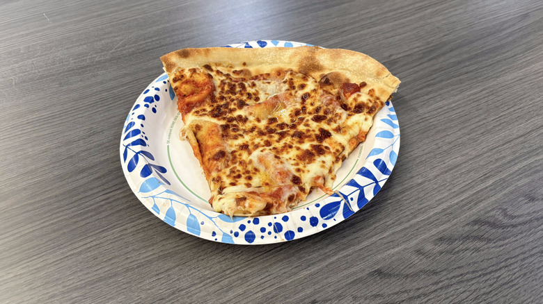 Sam's Club cheese pizza slice on paper plate on table