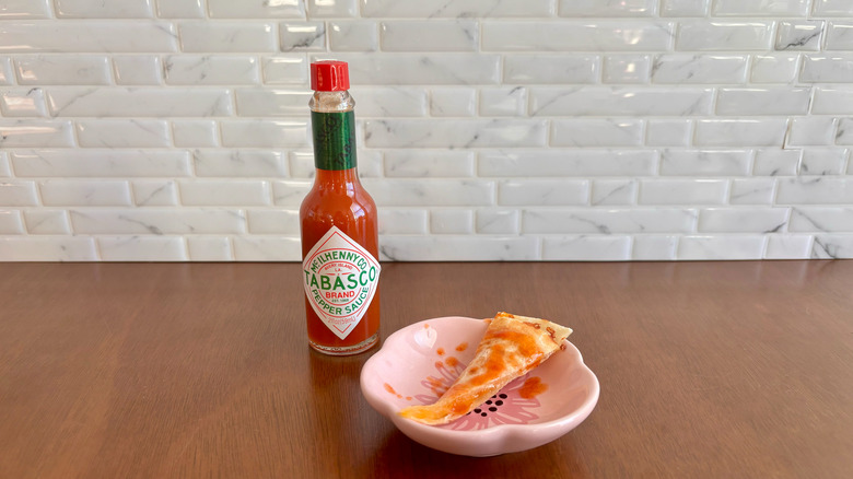 Tabasco Red Pepper sauce next to quesadilla slice