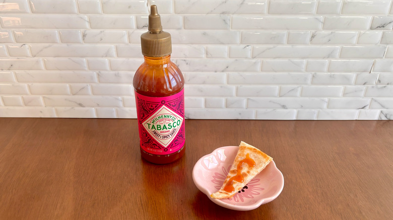 Tabasco sweet and spicy sauce bottle next to quesadilla slice