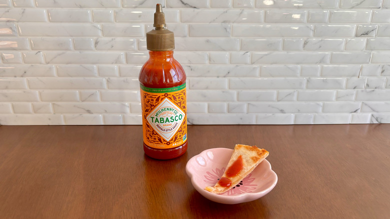 Tabasco Buffalo sauce bottle next to quesadilla slice