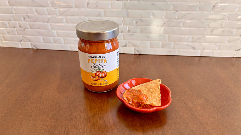 Trader Joe's pepita salsa next to chip on plate