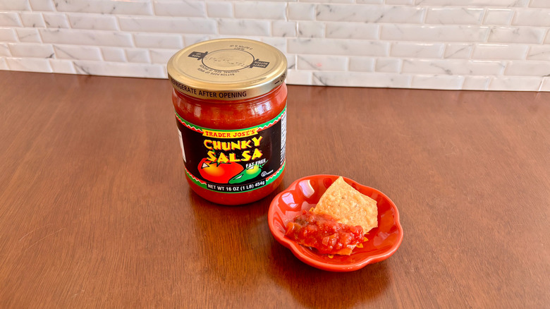 Trader Joe's chunky salsa next to chip on plate