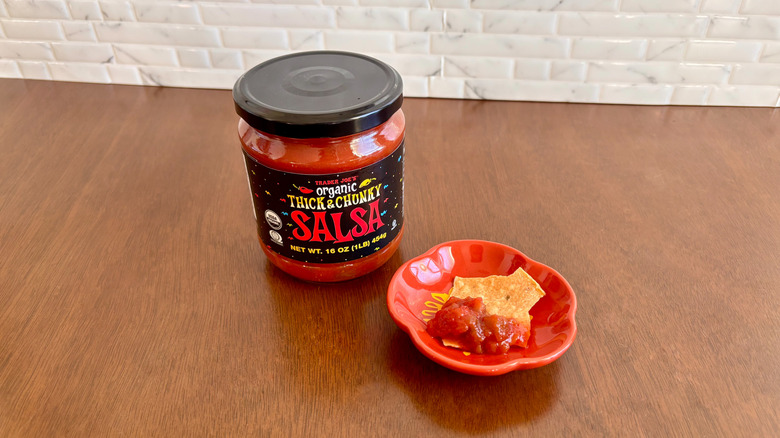 Trader Joe's thick and chunky salsa next to chip on plate