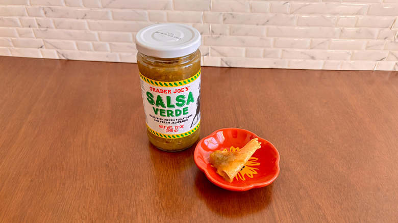 Trader Joe's salsa verde jar next to chip on plate