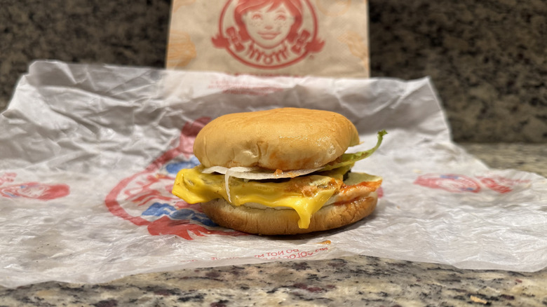 Jr. cheeseburger deluxe in Wendy's wrapper on counter