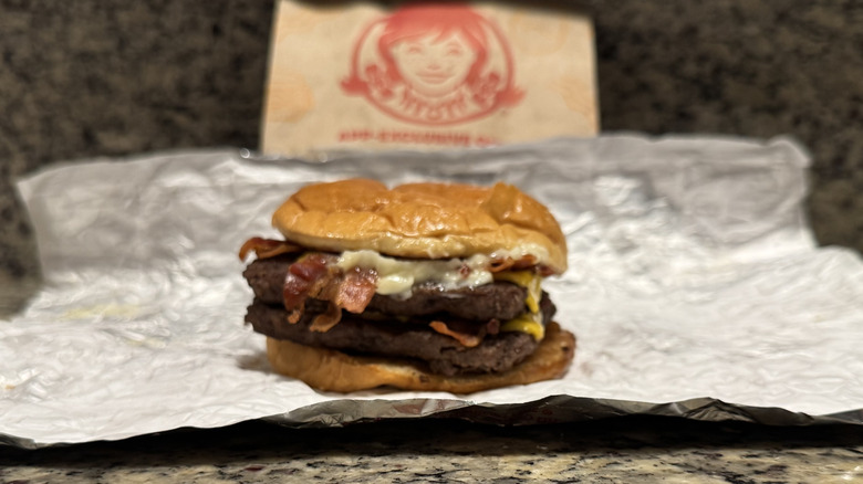 Baconator burger in Wendy's wrapper on counter