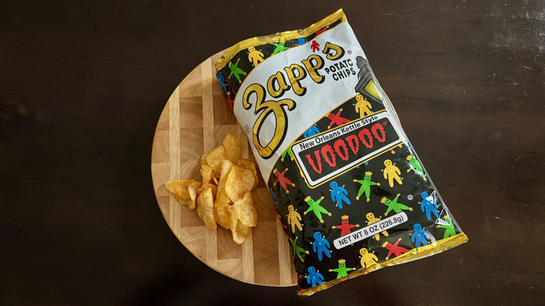 Zapp's Voodoo chips on a cutting board next to open bag