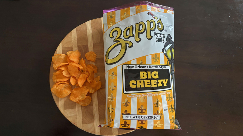 Zapp's Big Cheezy chips on cutting board next to open bag