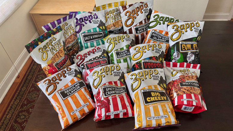 14 bags of Zapp's chips and pretzels on a table