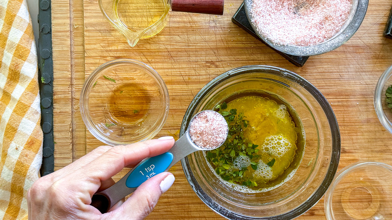 adding salt to bowl of vinaigrette