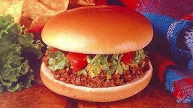 Vintage photo of a Taco Bell burger with lettuce, tomato, cheese, and taco meat.