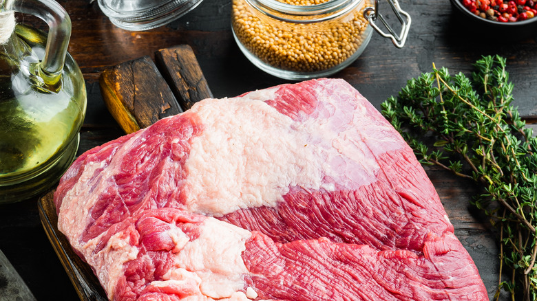 Packer brisket, raw beef brisket meat set,with ingredients for smoking making barbecue, pastrami, cure, on old dark wooden table background