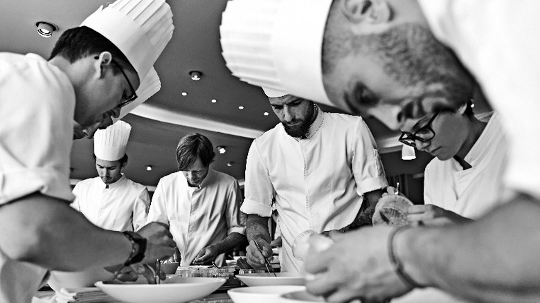 Chefs surround plates of food 