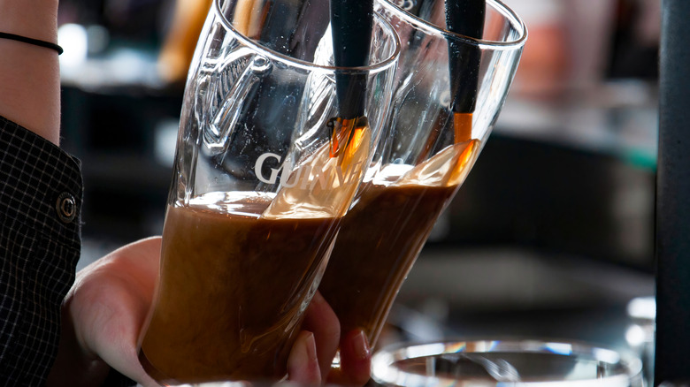 Two Guinness pints being poured