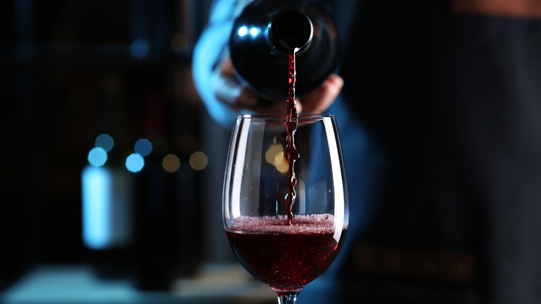 Hand pouring red wine into a glass