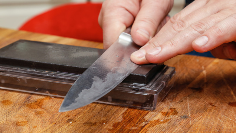 Sharpening a knife on whetstone