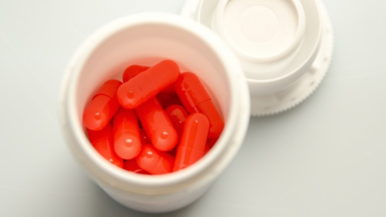Plastic jar of red pills