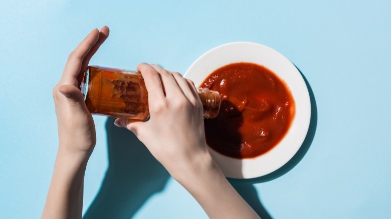 Pouring ketchup from glass bottle