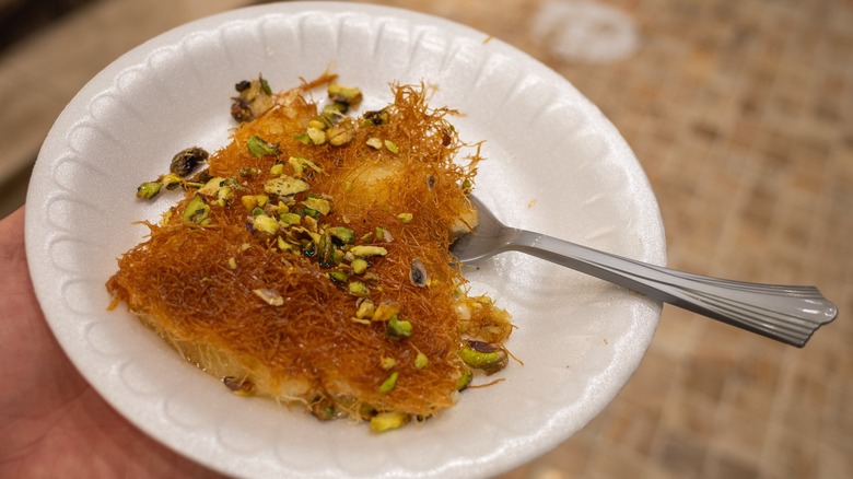 Knafeh on white plate, fork