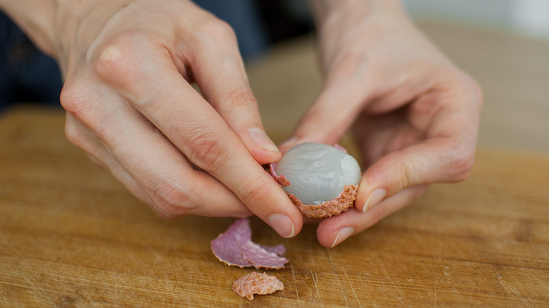 Person peeling lychee