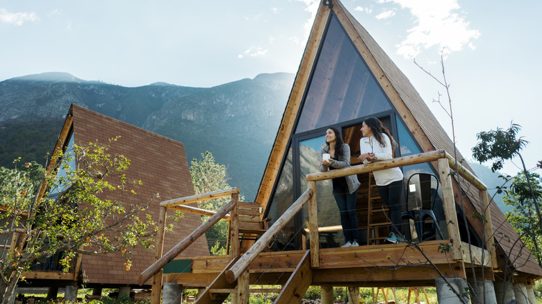 Two women are smiling on the veranda of a small eco-lodge in Mexico.