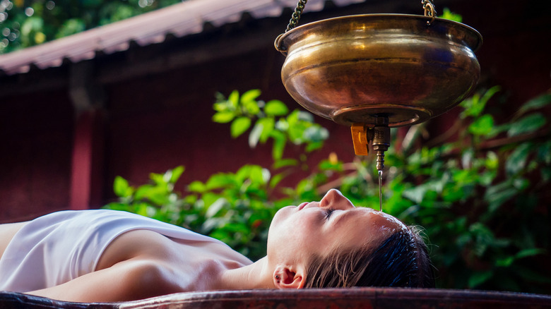 Woman receiving Ayurvedic oil treatment