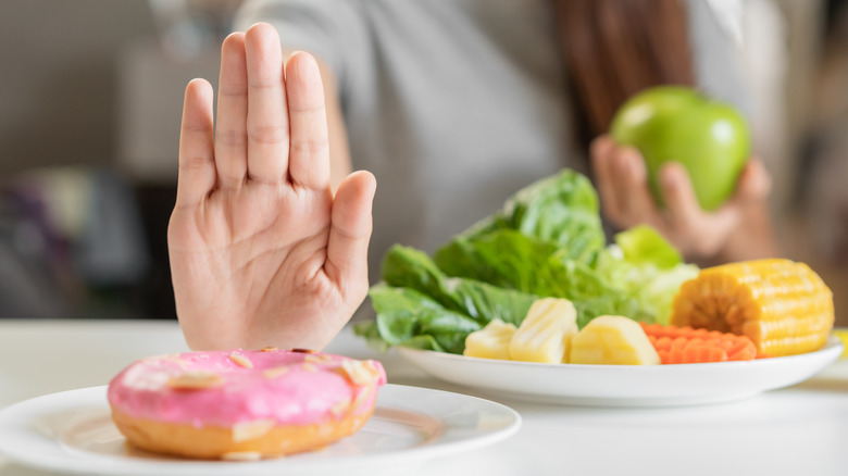 person pushing donut away