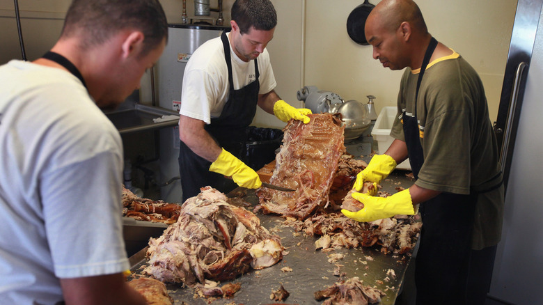 Cooks processing smoked pork