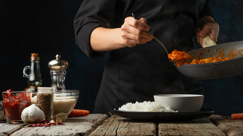 Chef plating a rice dish