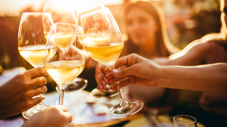 glasses of white wine raised for toast