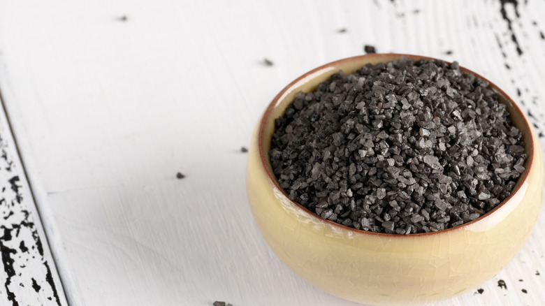 Black salt in wooden bowl