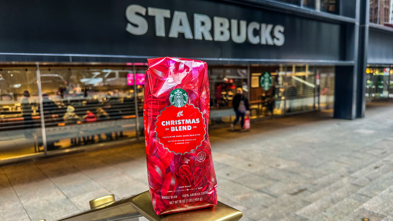 Starbucks Christmas Blend bag in front of a Starbucks cafe