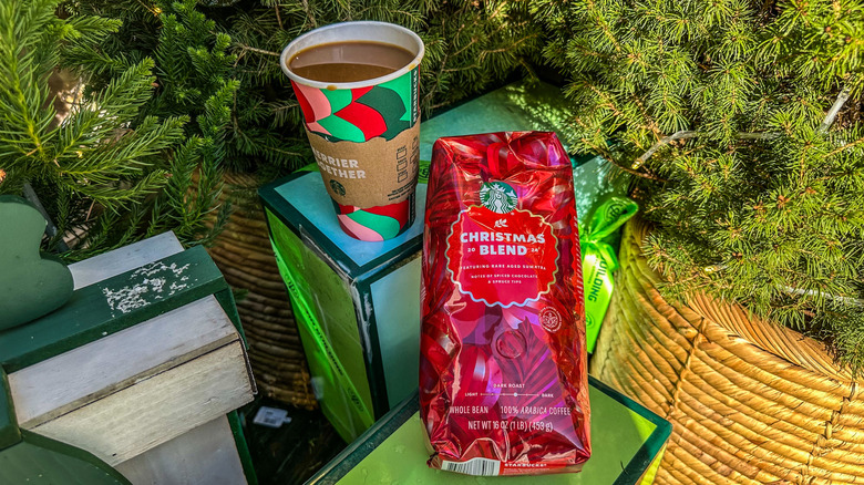 Starbucks Christmas Blend with a cup of coffee next to Christmas trees