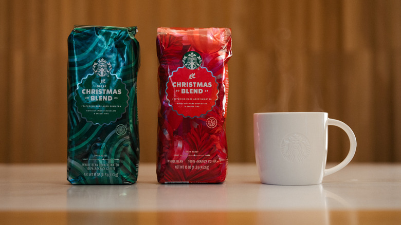 Two bags of Starbucks Christmas Blend with a white coffee mug